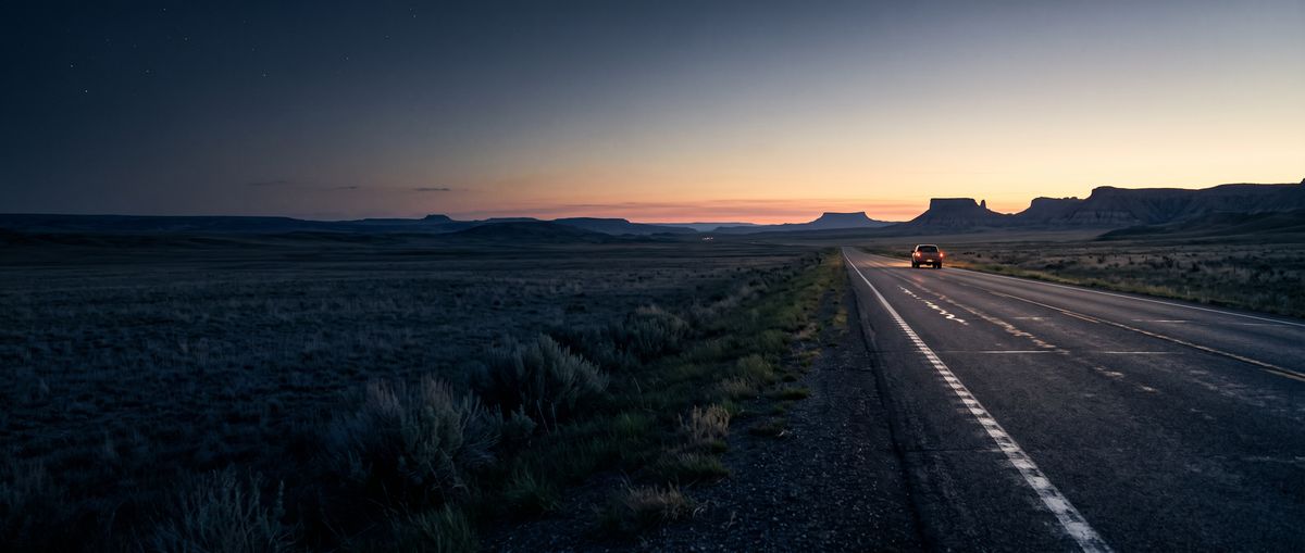 Highway running across open high-desert country at dusk
