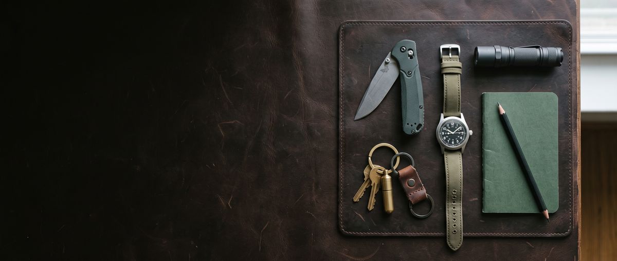 Everyday carry on leather: folding knife, watch, flashlight, keys and notebook