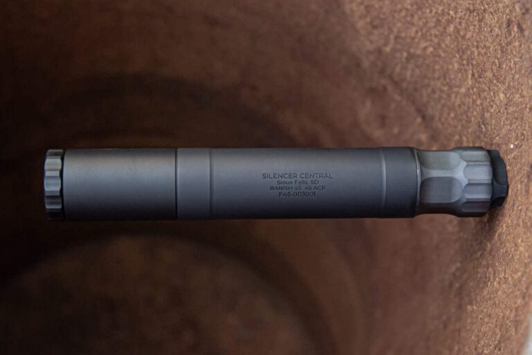BANISH 45 suppressor — modular titanium multi-caliber pistol suppressor in matte black Cerakote finish, standing upright on a weathered surface