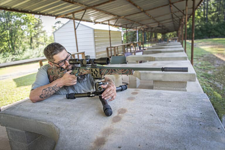 man shooting a suppressed rifle