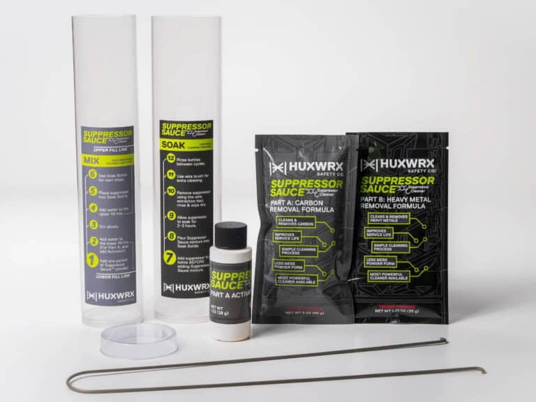 Huxwrx Suppressor cleaning kit: two tall bottles, a small bottle, two sachets, a clear cap, and two metal cleaning rods on a white surface.