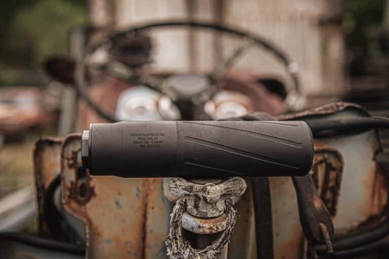 Close-up of a black throttle grip on a rusty, abandoned vehicle; steering wheel blurred in the background.