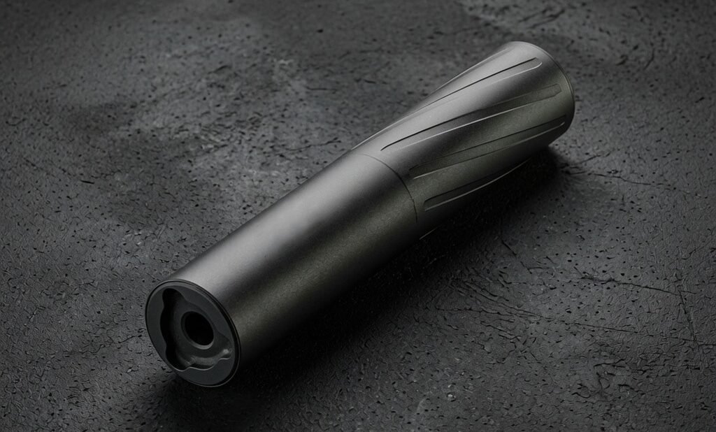 BANISH 9 cool background - PopularSuppressors Black cylindrical flashlight with a textured grip resting on a dark, rough surface.