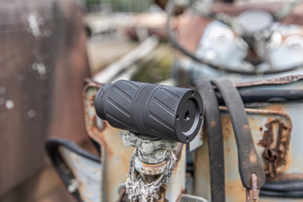 Close-up of a textured black motorcycle handlebar grip attached to a rusted metal frame.
