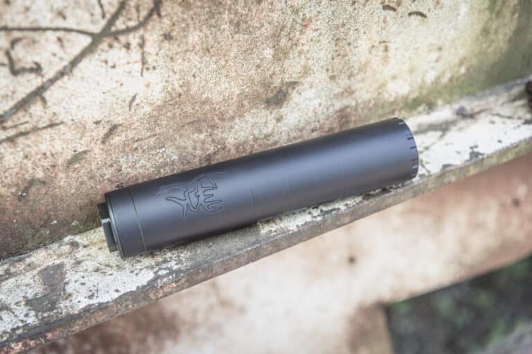 Black cylindrical device resting on a mossy, weathered stone ledge (close-up).