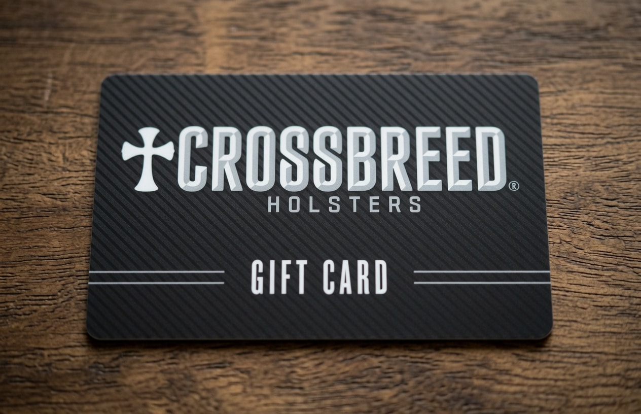 CrossBreed Holsters gift card on a dark striped card resting on a wooden surface, displaying the brand name and'Gift Card' text.