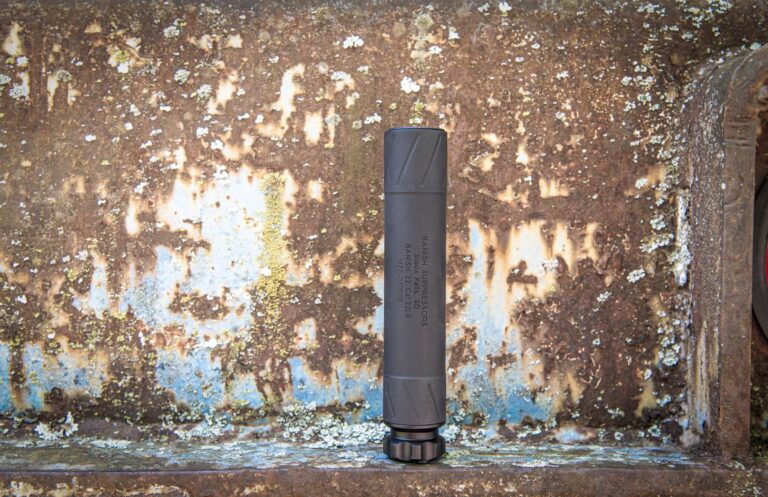 BANISH 22 suppressor — titanium rimfire can standing upright on a weathered metal surface